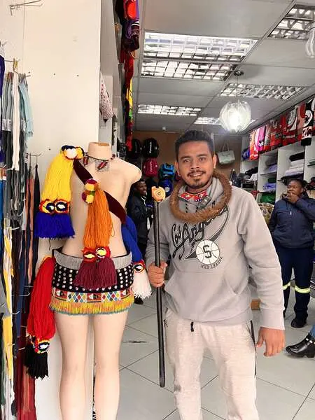 Saif in a clothing shop beside traditional garments