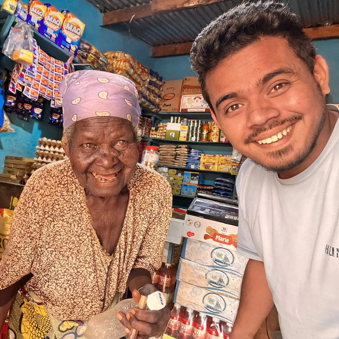 Saif taking a selfie with an elderly shopkeeper inside her shop